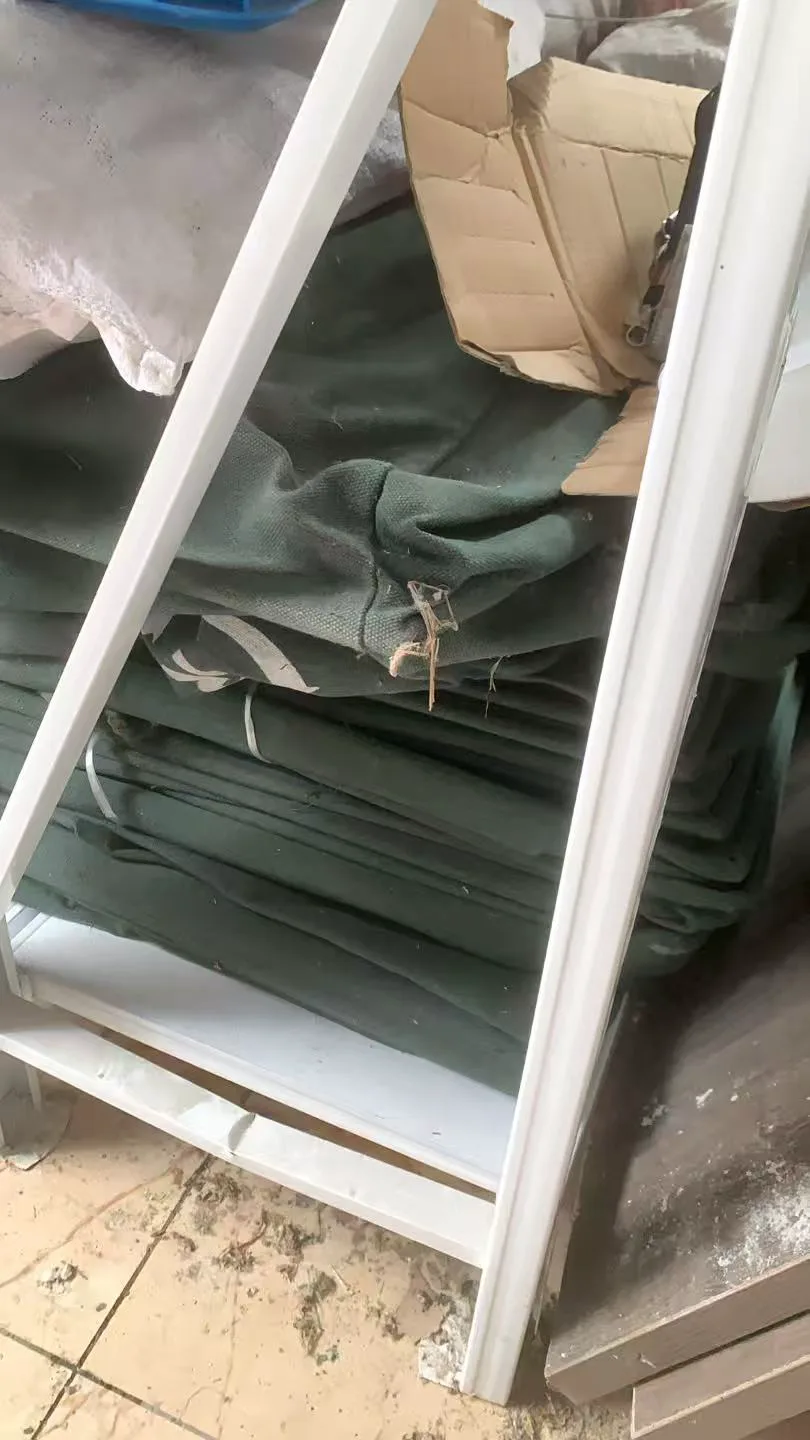 旧窗框旁堆放的绿色帆布和纸箱